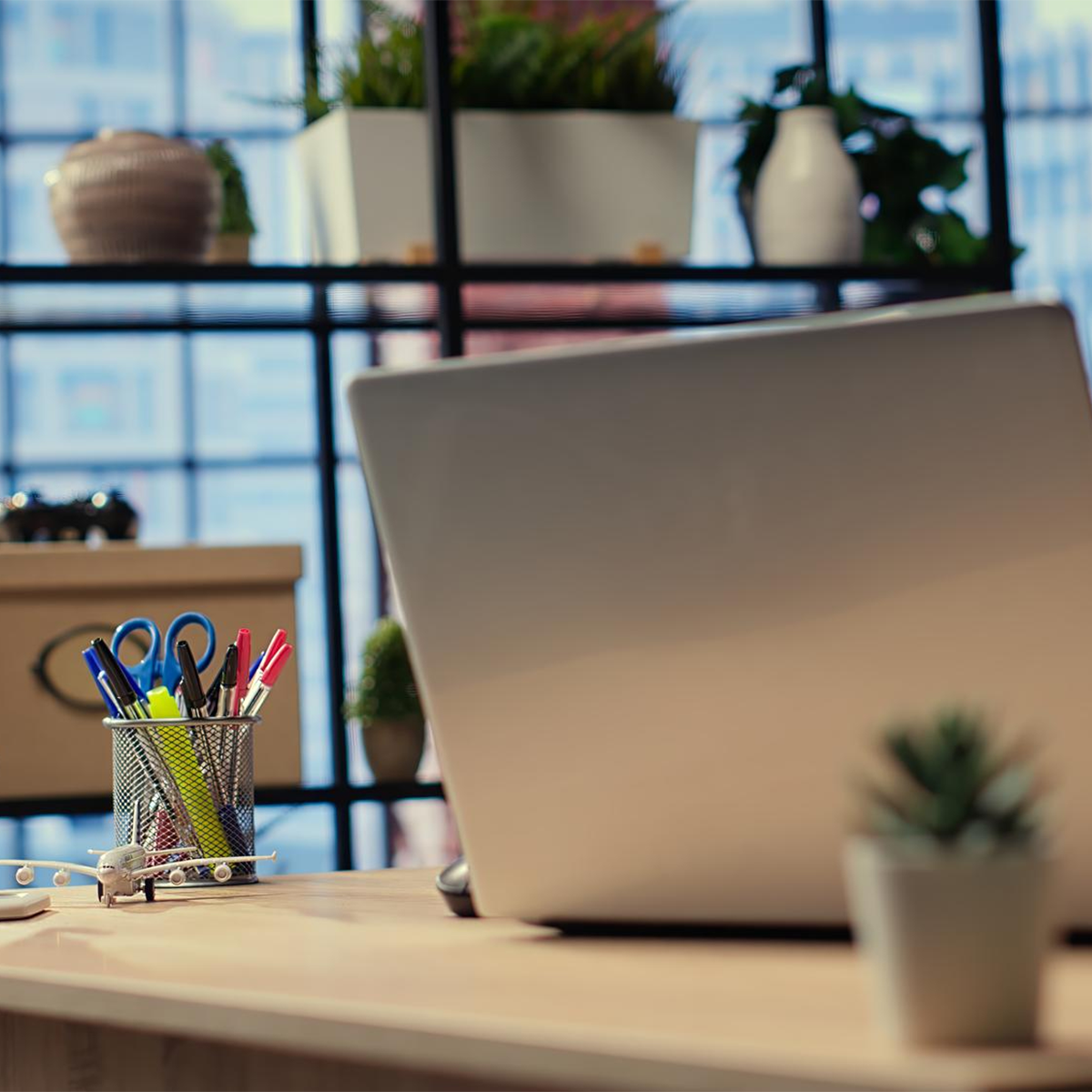 Moderner Schreibtisch mit Laptop, Headset und organisiertem Arbeitsumfeld